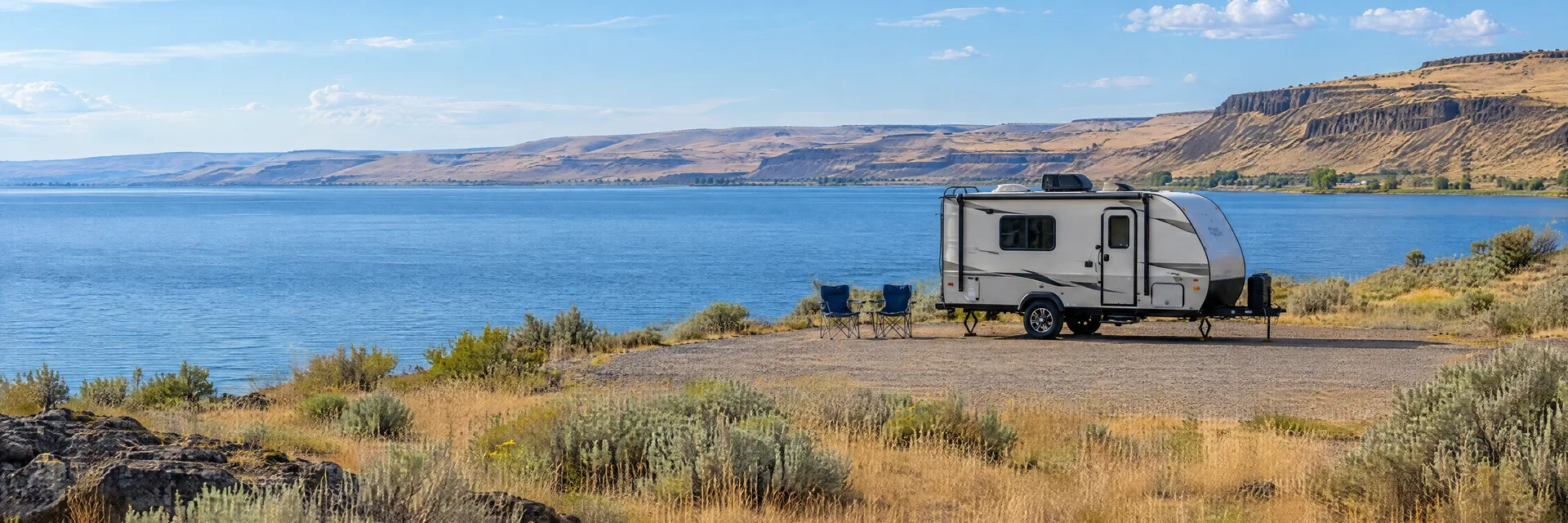 Illustration of a compact travel trailer at a fictional camping setting inspired by Moses Lake, WA.