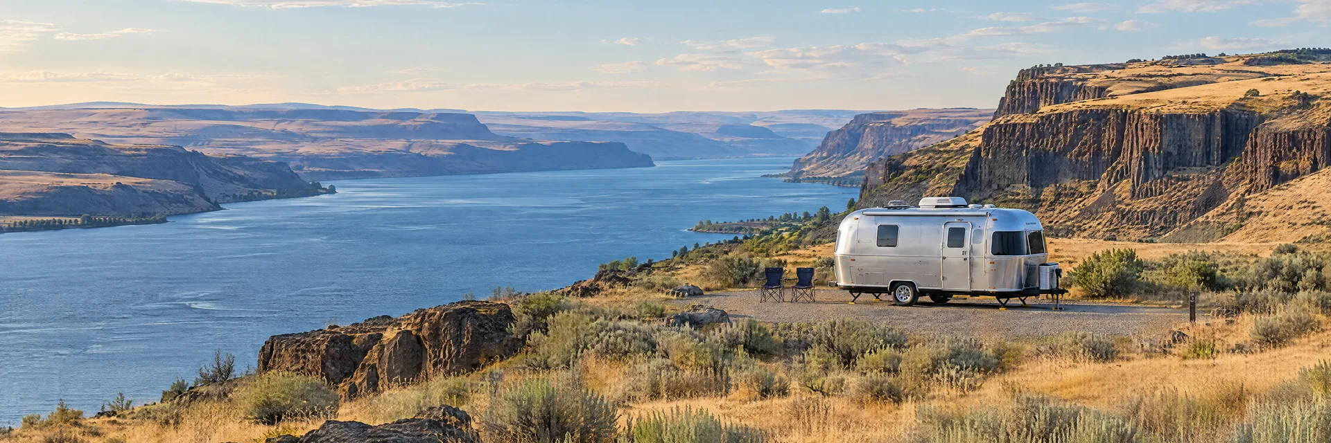Illustration of a rounded silver travel trailer at a fictional camping setting inspired by Vantage, WA.