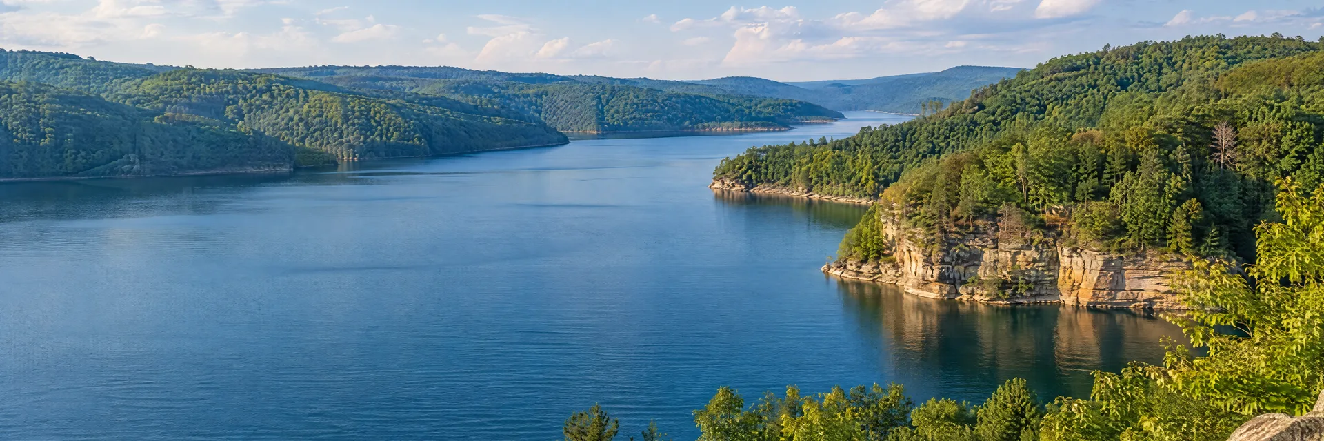Illustration inspired by Summersville, WV: west Virginia deep blue reservoir with wooded hills and sandstone shoreline, no exact named cliff.