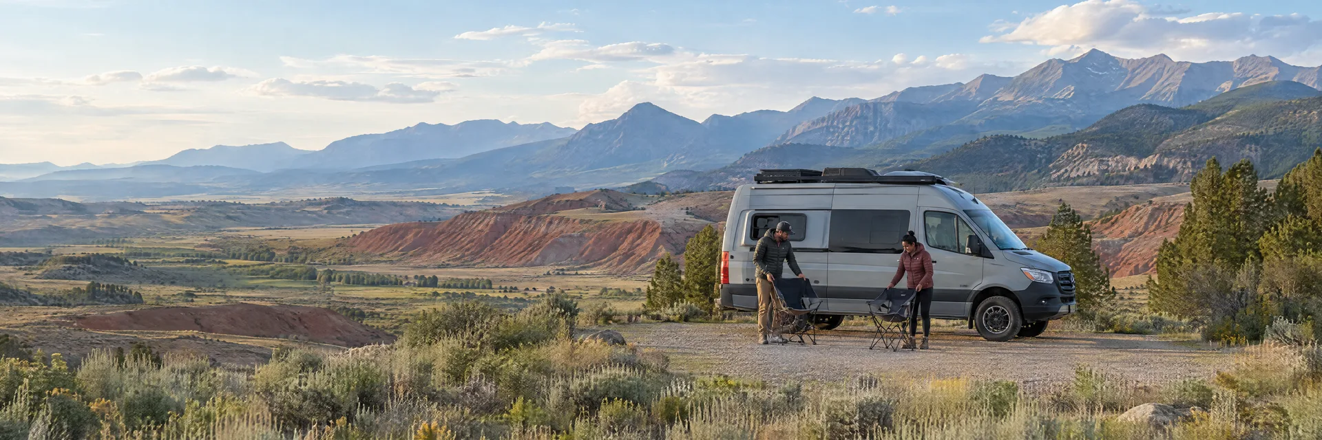 Illustration of campers enjoying setting up camp beside a camper van in a fictional camping setting inspired by Dubois, WY.