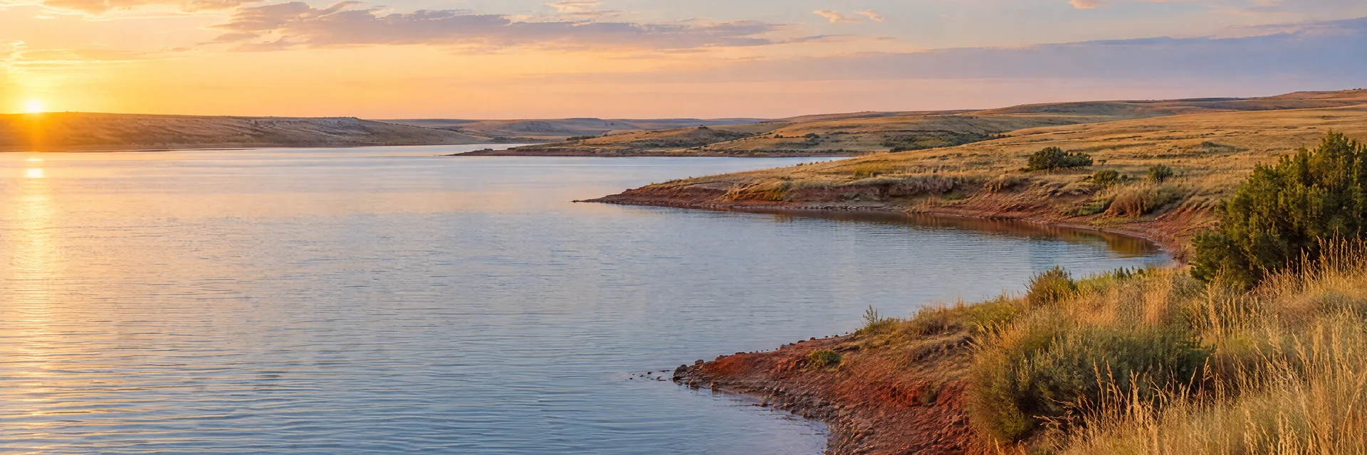 AI-generated illustration inspired by Foss Reservoir: Oklahoma prairie reservoir, low golden grassland and gently rolling red-earth shore.