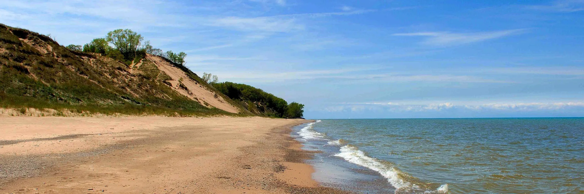 A sandy Lake Michigan beach and grassy dunes in Indiana Dunes National Park.