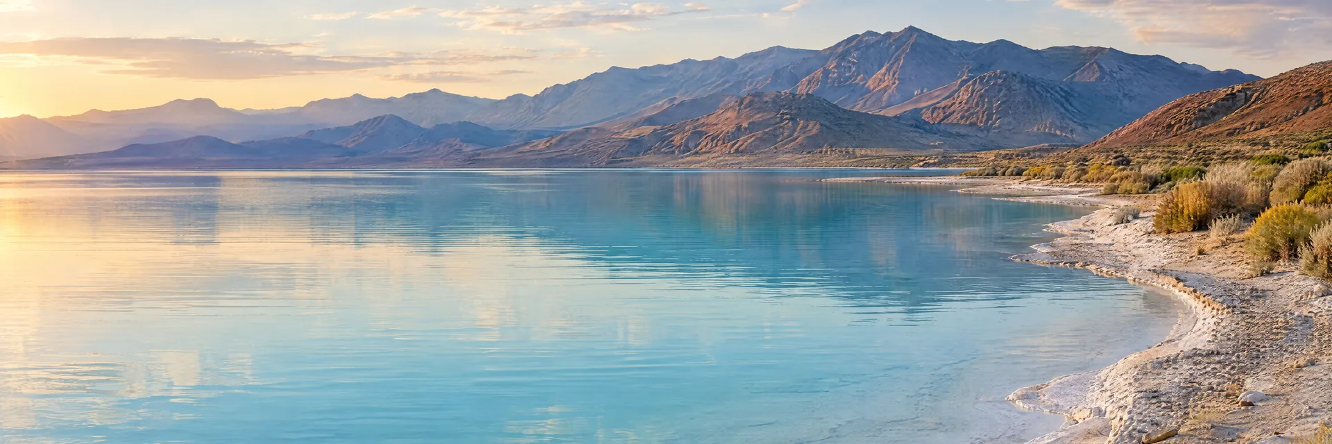 AI-generated illustration inspired by Pyramid Lake: Nevada desert lake, milky blue water, arid mountains and pale mineral shore.