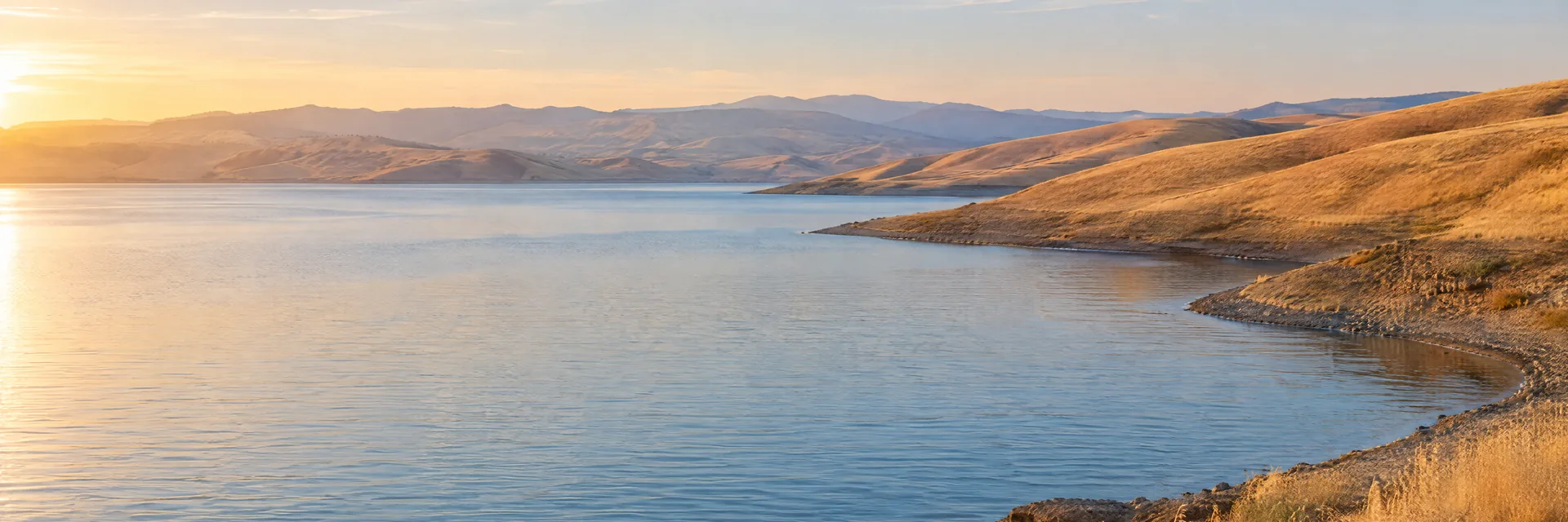 AI-generated illustration inspired by San Luis Reservoir: California reservoir amid dry golden grass hills with almost no trees.