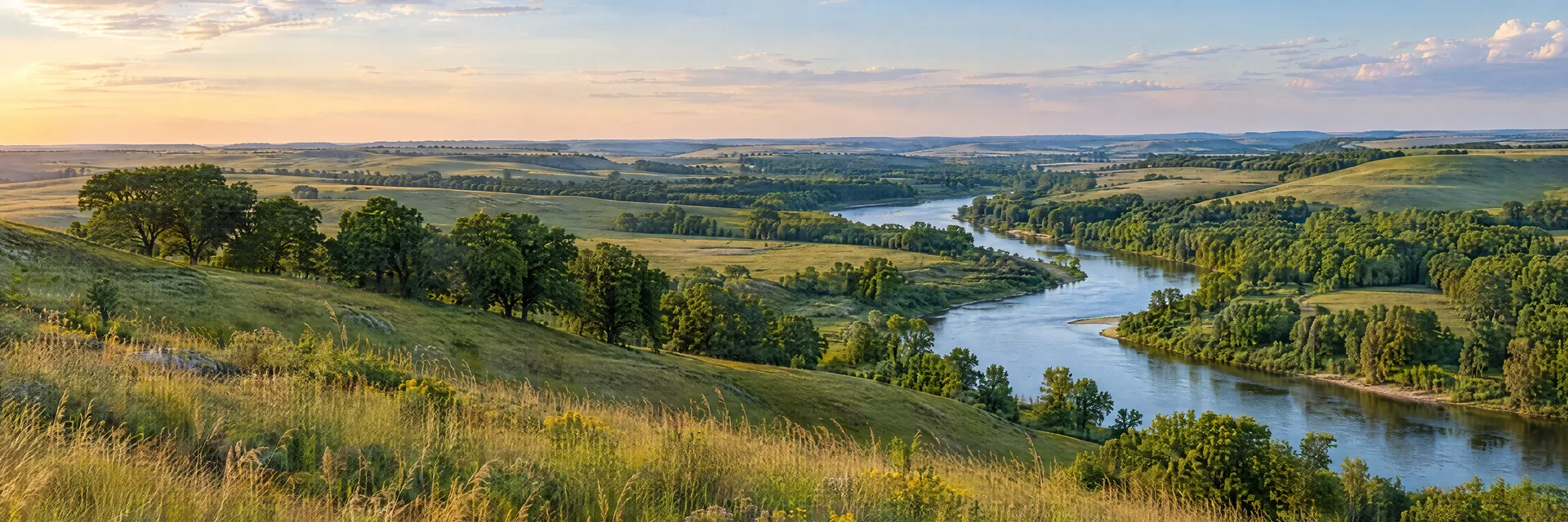 Illustration of representative natural scenery in Iowa: rolling prairie grassland, scattered oak groves and a winding river.