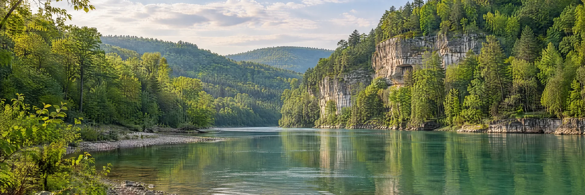 AI-generated illustration inspired by Kentucky: Kentucky wooded river valley, limestone cliffs and lush mixed hardwood forest, emerald river and a pebbled bank.