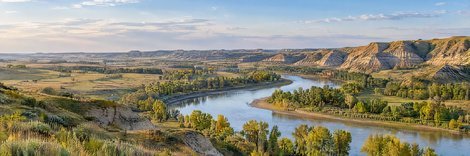 AI-generated illustration inspired by North Dakota: North Dakota rolling prairie and soft eroded badland bluffs, a curving river, scattered cottonwoods and broad open sky.