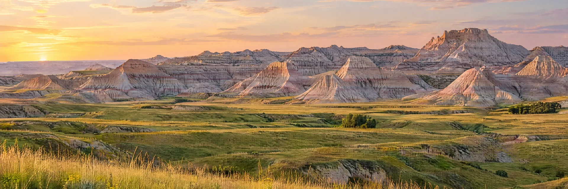 AI-generated illustration inspired by South Dakota: South Dakota badlands and prairie, pale layered eroded buttes beyond a green-gold grassland foreground.